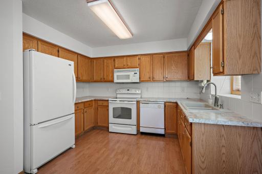 The heart of the home boasts a bright kitchen with newer countertops and sink, offering both an eat-in dining area