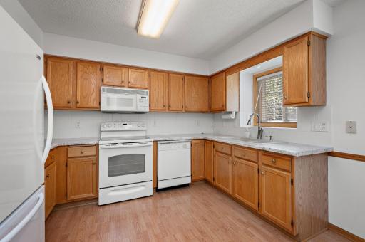 The heart of the home boasts a bright kitchen with newer countertops and sink, offering both an eat-in dining area