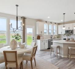 Soaring windows provide a striking view in the home and drench the dining room in sunlight! Photo of model home.