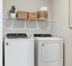 Conveniently located off the primary suit the laundry room is both functionally placed and spacious! Photo of model home.