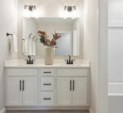 16.Conveniently located next to the guest bedrooms, the guest bath impresses with modern cabinets, dual sinks and quartz countertops! Photo of model home.
