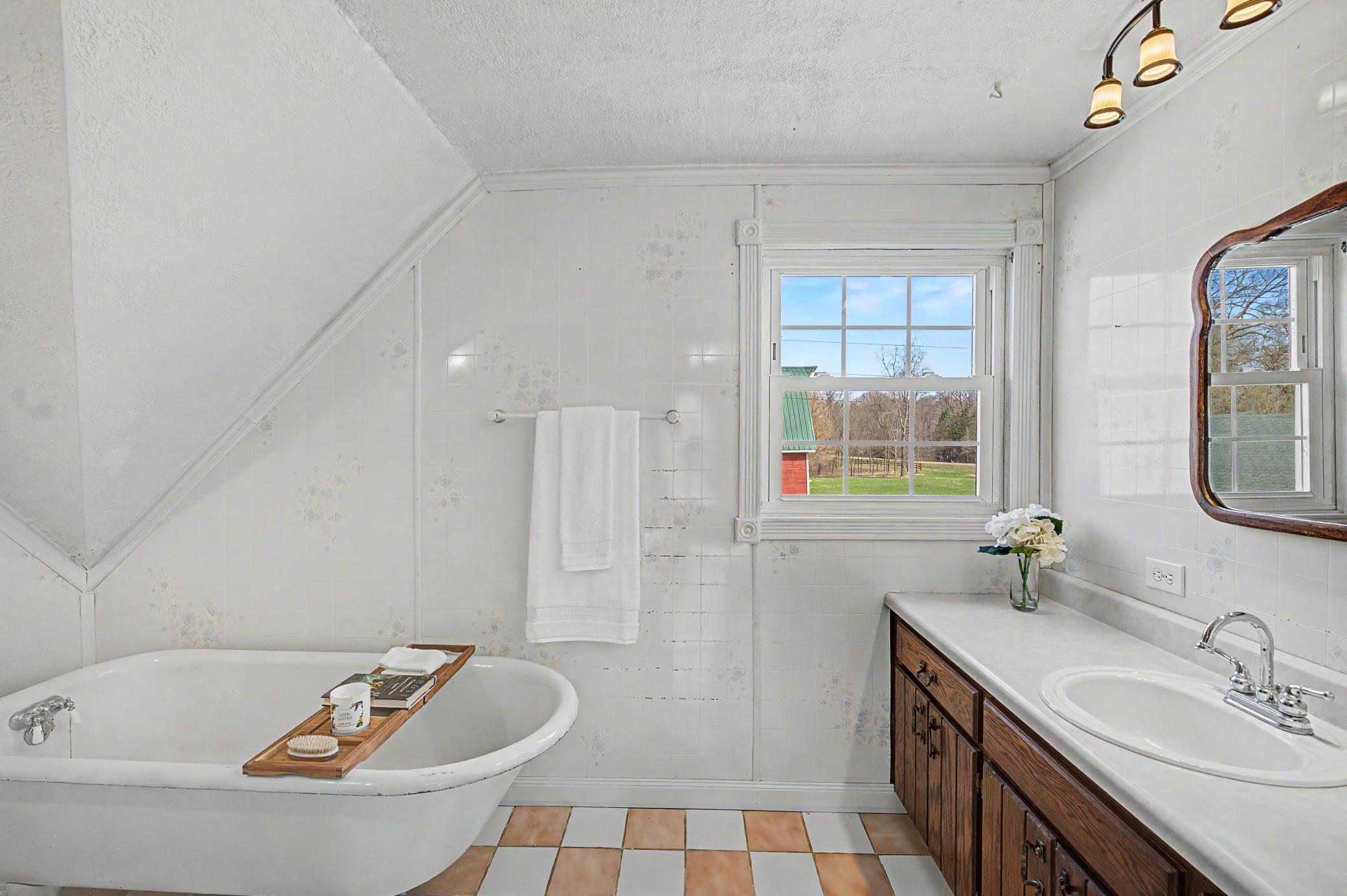 Upper level bathroom complete with a deep claw-foot bathtub perfect for soaking in.