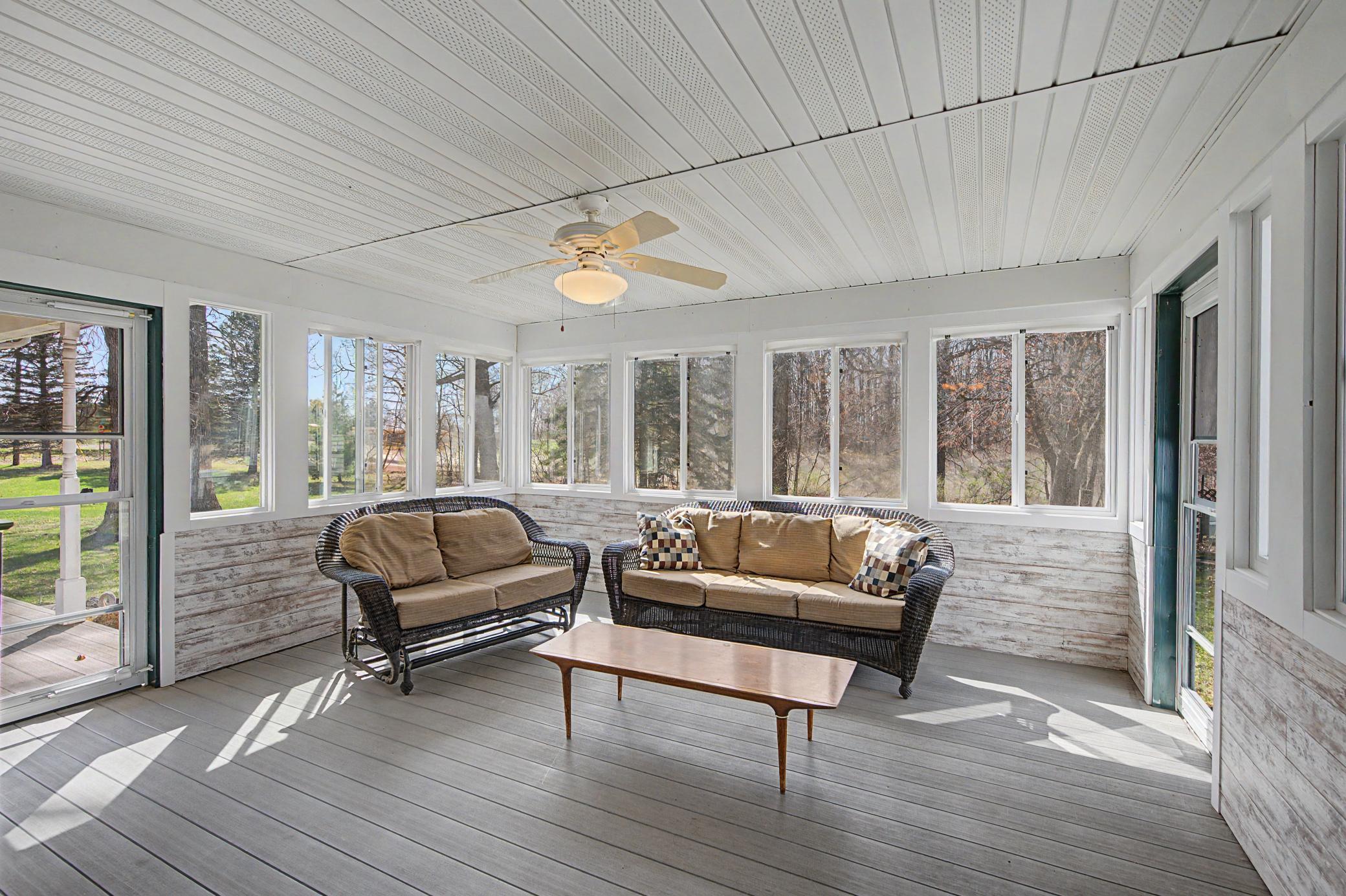 Covered 3 season porch overlooks the side yard and steps out to both the wrap around covered front proch and the expansive patio in the back yard.