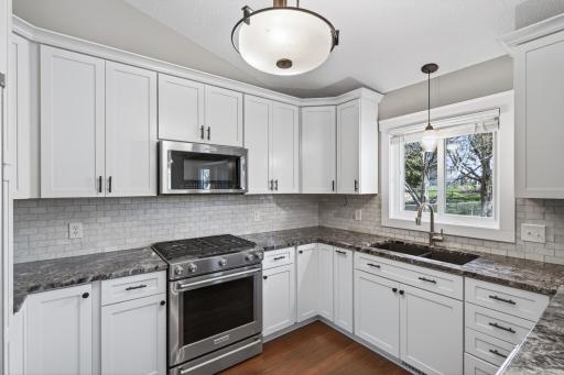 High-end stainless steel appliances, granite countertops, and a Carrera marble backsplash.