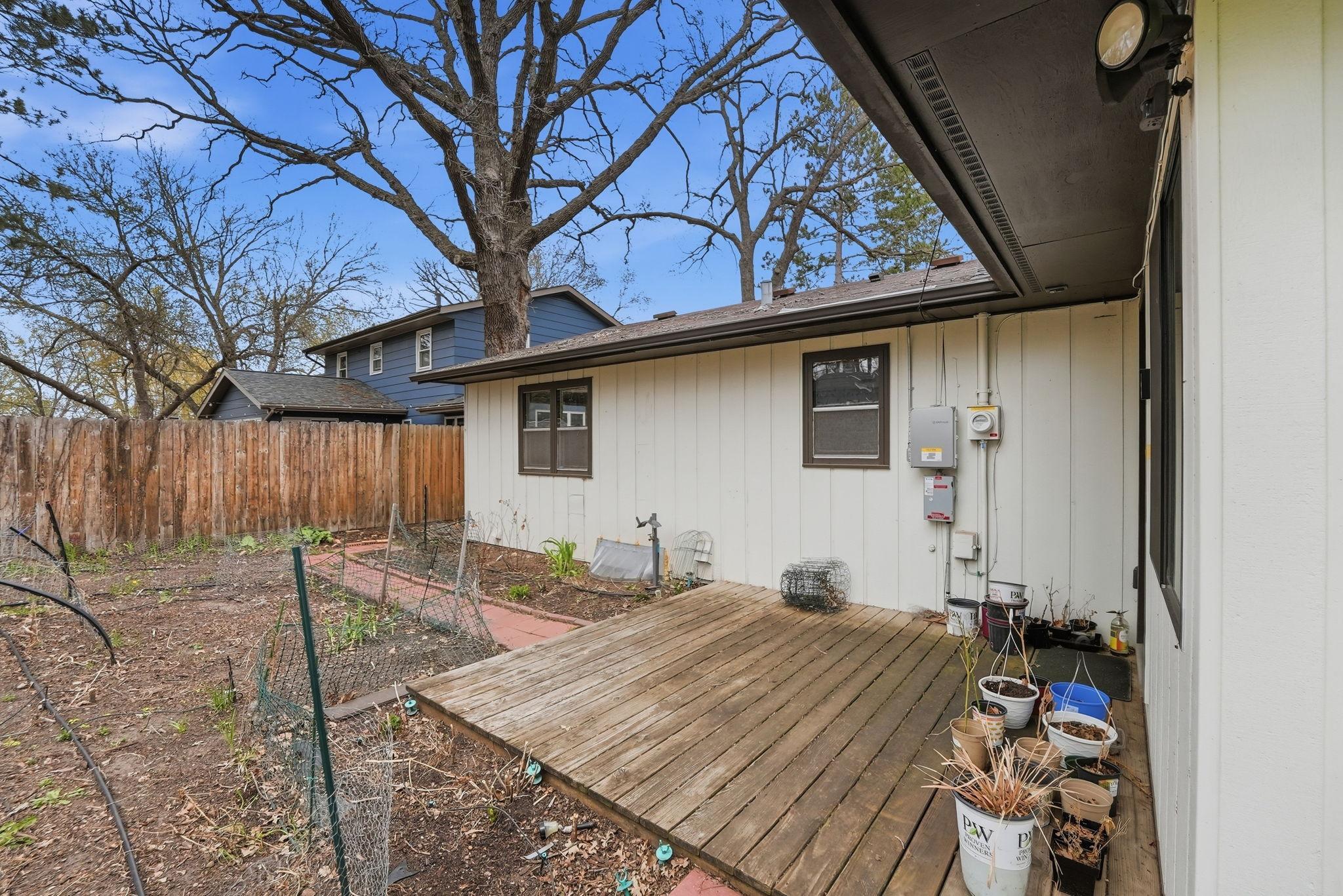 Small deck off the back of the home overlooking flower garden
