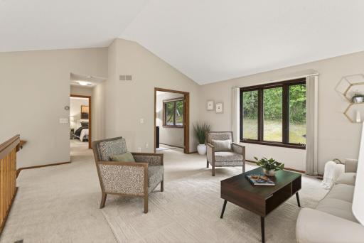 Living room is saturated in natural light and leads to the office:den