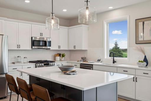 Large center island with cabinets on both front and backside. Photos and/or illustrations are of like home and may not depict actual home plan configurations. Features, materials and finishes may contain options that are not included in price.