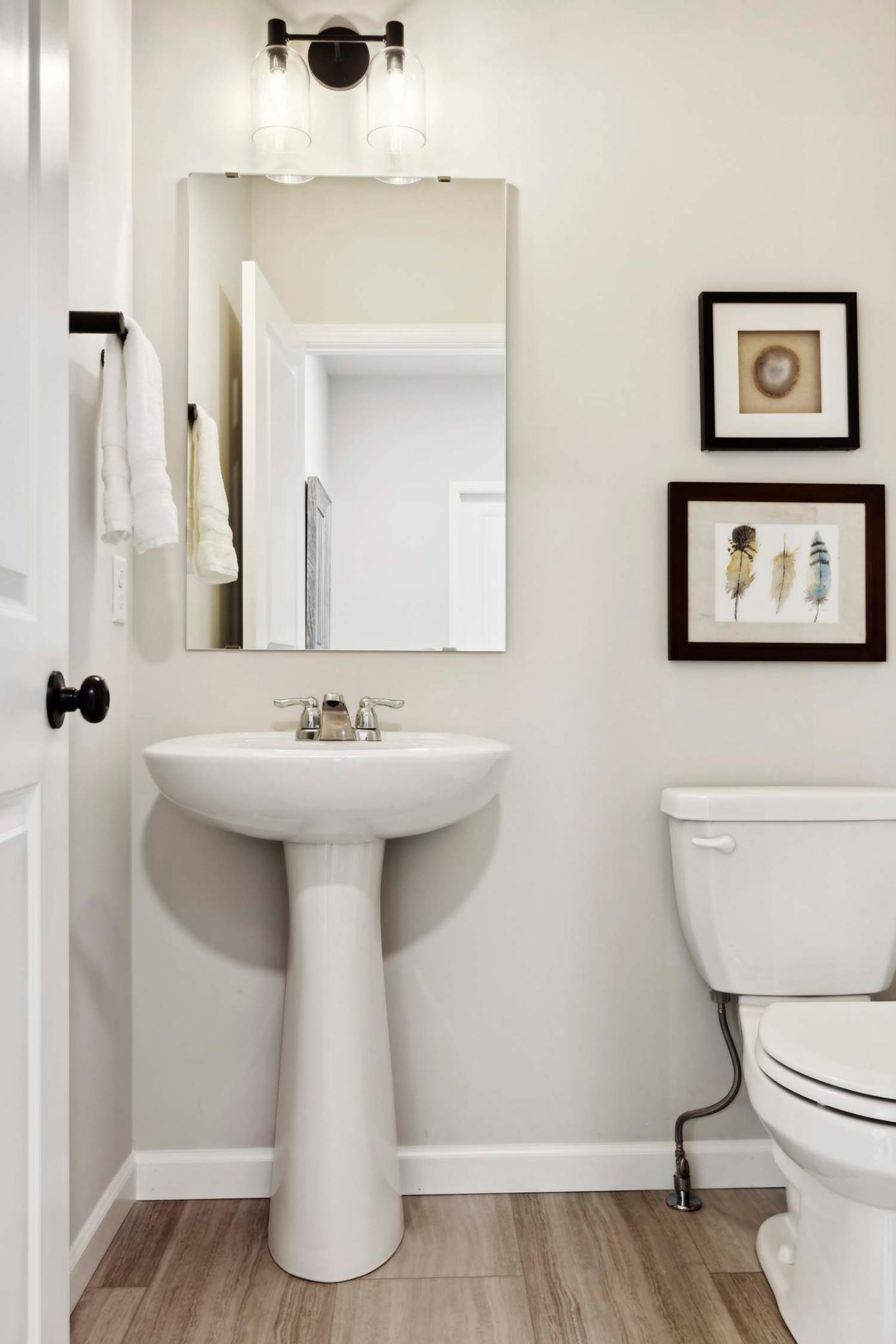 Main floor powder room with pedestal sink. Photos and/or illustrations are of like home and may not depict actual home plan configurations. Features, materials and finishes may contain options that are not included in price.