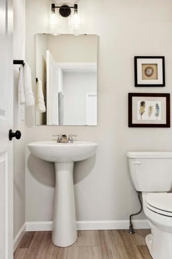 Main floor powder room with pedestal sink. Photos and/or illustrations are of like home and may not depict actual home plan configurations. Features, materials and finishes may contain options that are not included in price.