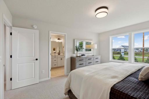 Primary suite has private bath and walk-in closet. Photos and/or illustrations are of like home and may not depict actual home plan configurations. Features, materials and finishes may contain options that are not included in price.