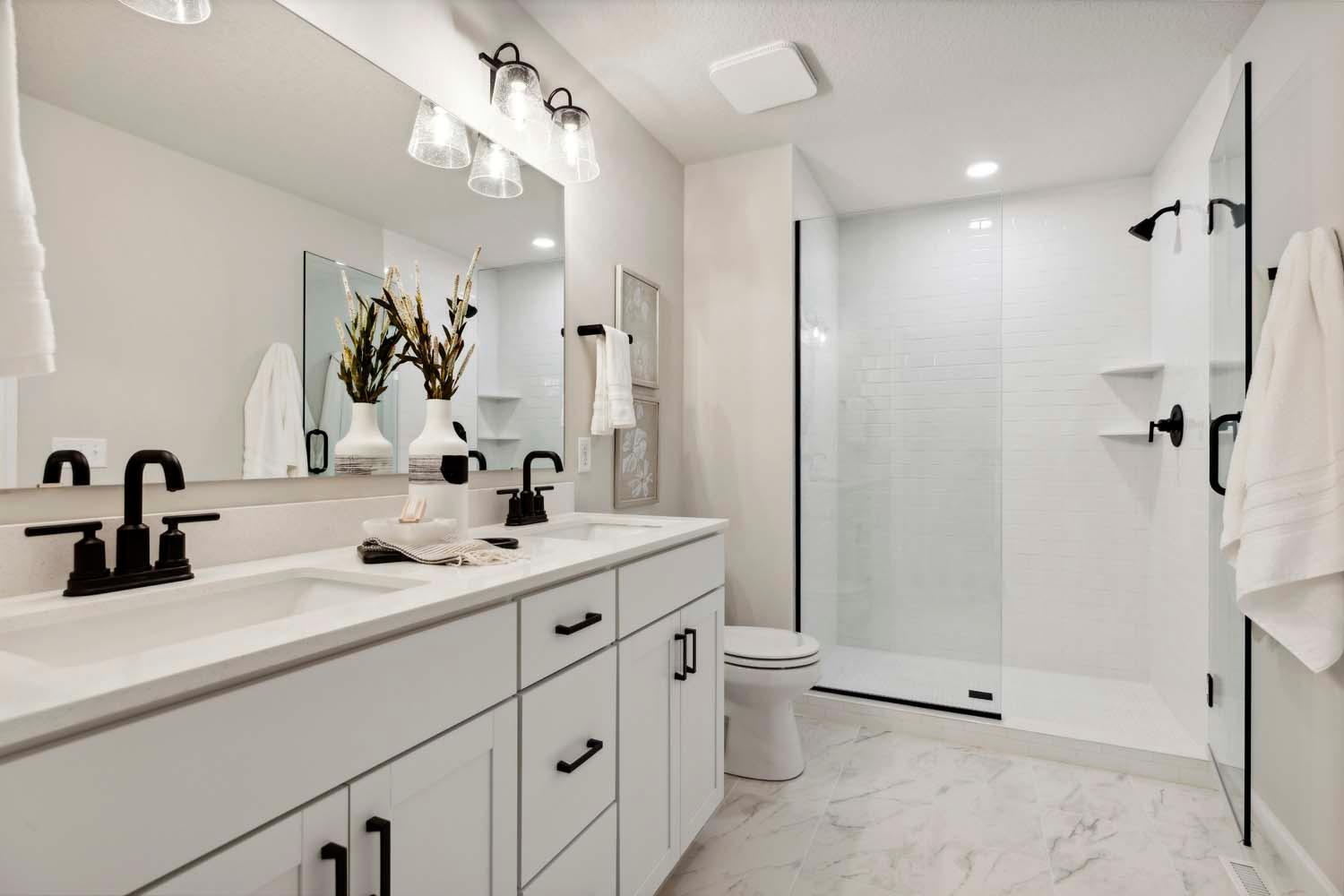 Primary bath includes single sink w/ quartz countertops & lg shower plus LVT floors. Photo is of like home & may not depict actual home plan configurations. Features, materials & finishes may contain options that are not included in price.