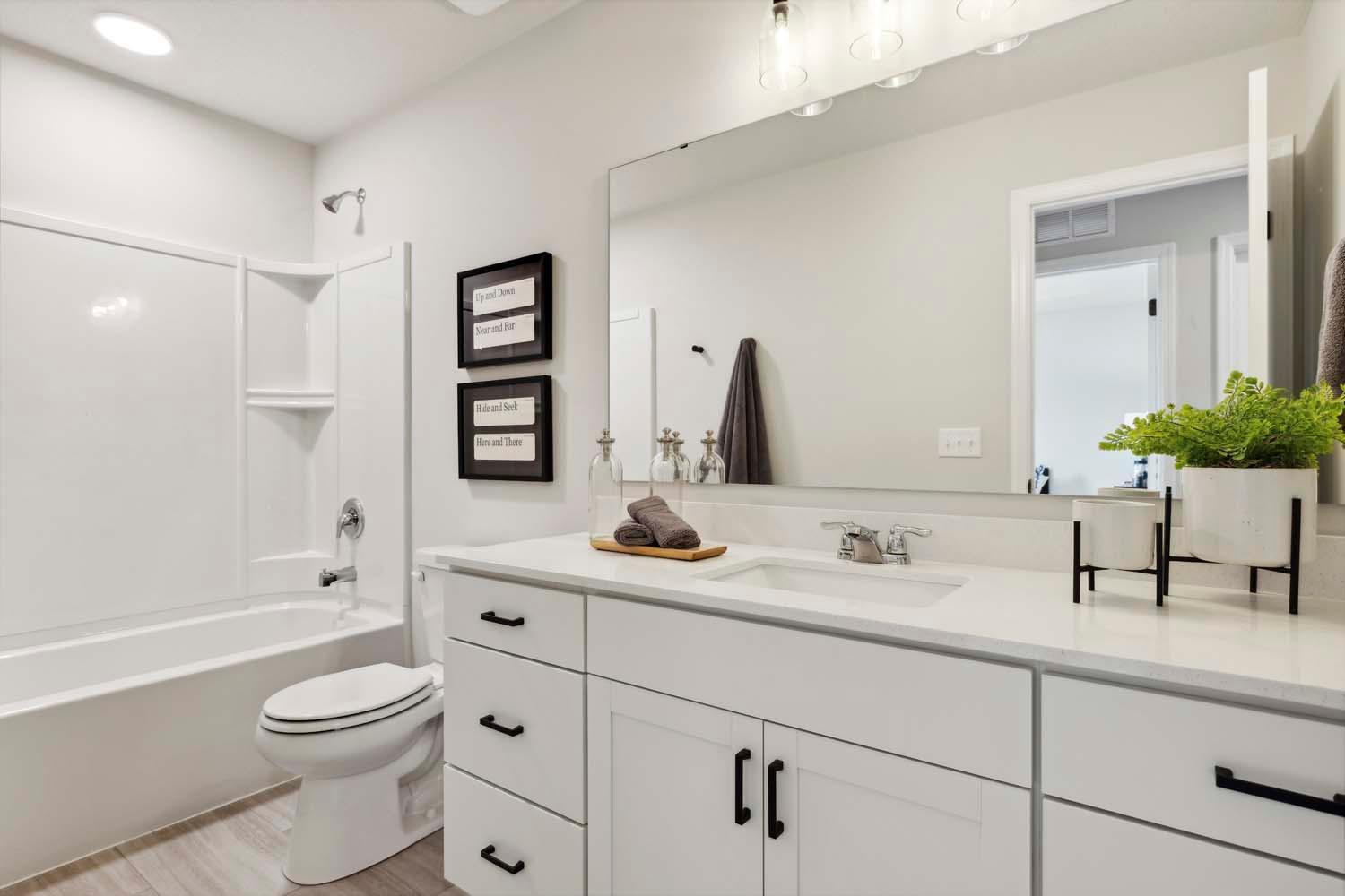 Upper level hall bath w/ large vanity w/ quartz countertops. Photos and/or illustrations are of like home and may not depict actual home plan configurations. Features, materials and finishes may contain options that are not included in price.