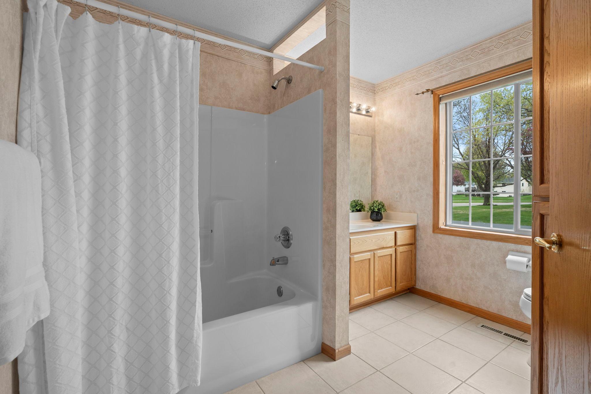Spacious main bathroom featuring a tub/shower combination, large vanity, linen closet and ample natural light from the oversized window. Located off the living room and adjacent to bedroom #2.