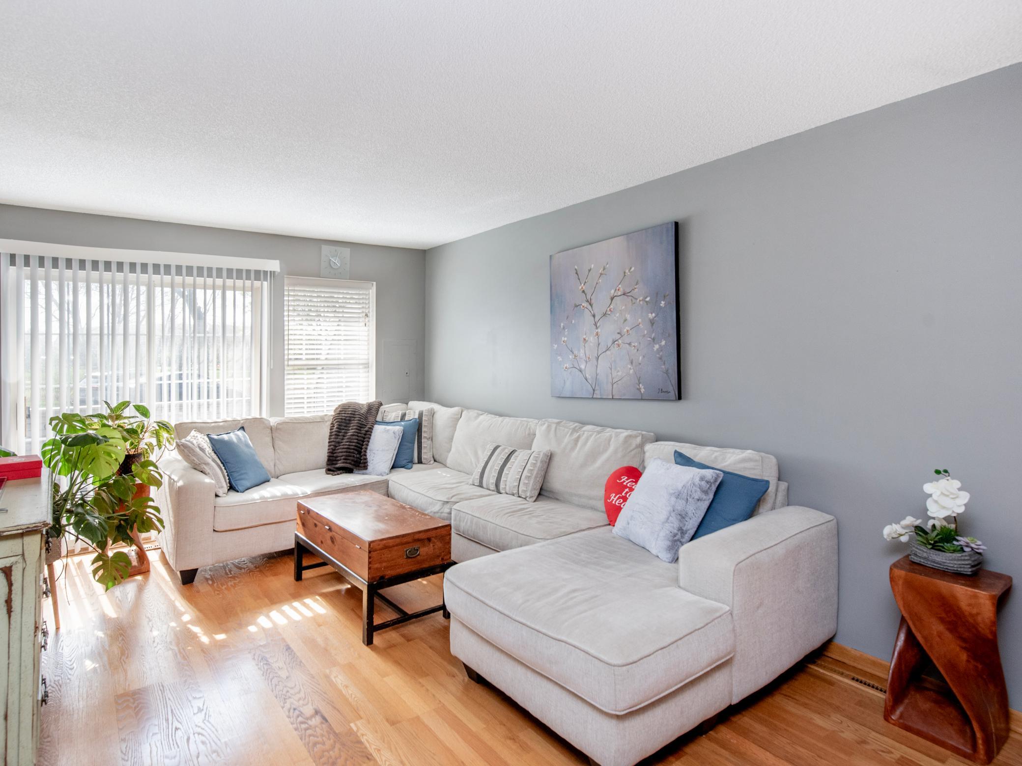 Living room features hardwood floors and patio sliders leading to front deck.