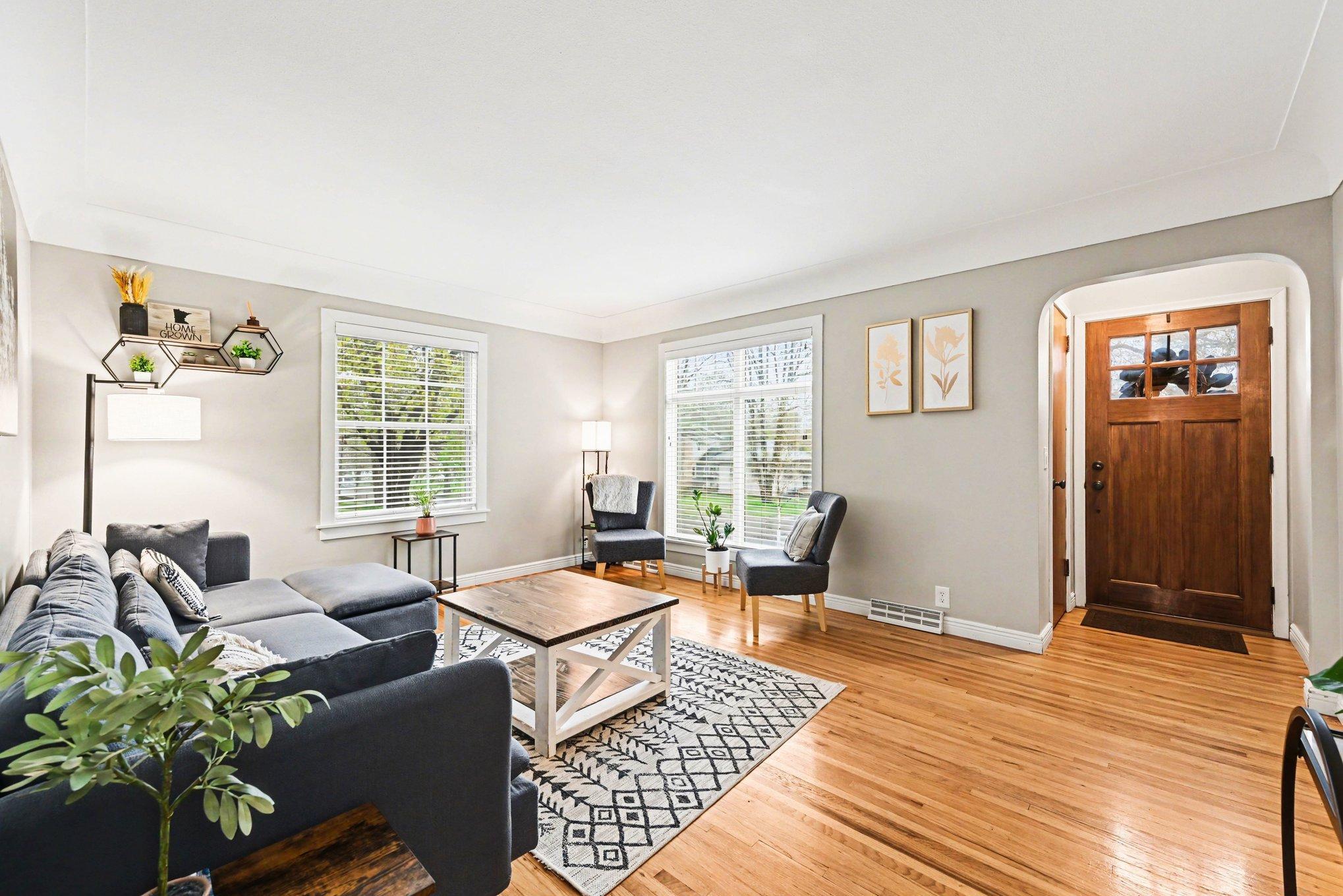 Spacious living room complete with pristine hardwood floors, large windows and plenty of natural light
