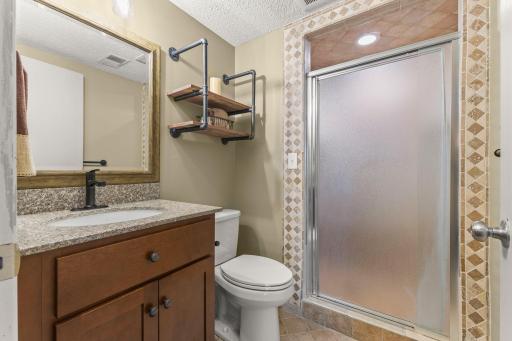 Lower level 3/4 bathroom with newly tiled shower and refreshed paint.
