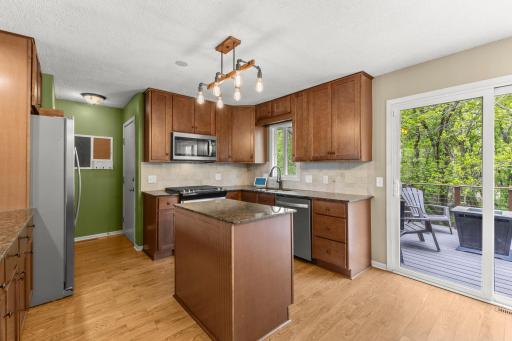 Kitchen island, storage pantry, newer light fixtures and appliances. Tiled backsplash, eat-in kitchen area, great storage and countertop space.