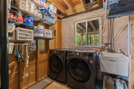 Lower level laundry room with sink and newer washer and dryer.