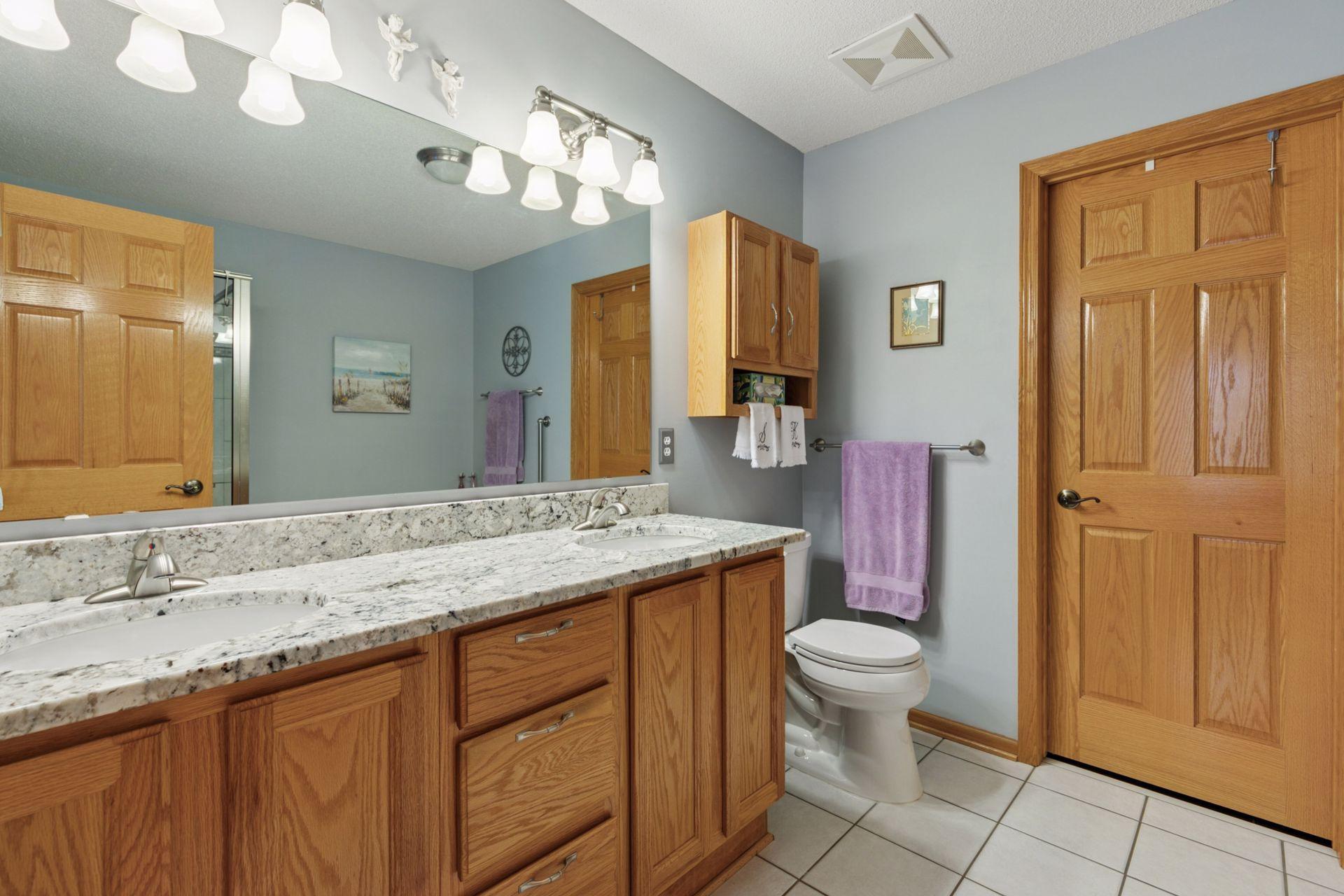 "White" granite, dual sink vanity top and ceramic tile floor are neutral and appealing.