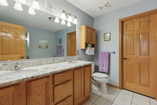 "White" granite, dual sink vanity top and ceramic tile floor are neutral and appealing.