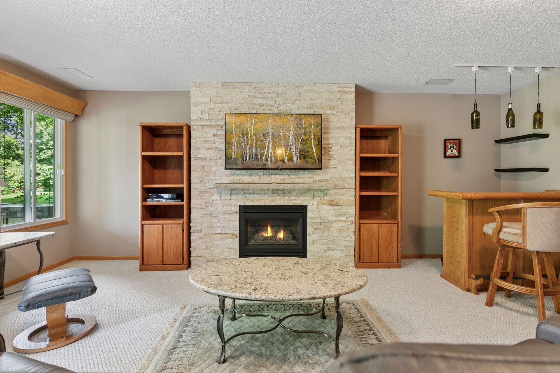 The lower level is a pleasant surprise with this beautiful gas fireplace. This room is 20.67' X 18' and walks out to a 10' X 13' concrete patio. There is also a large window as you can see here.