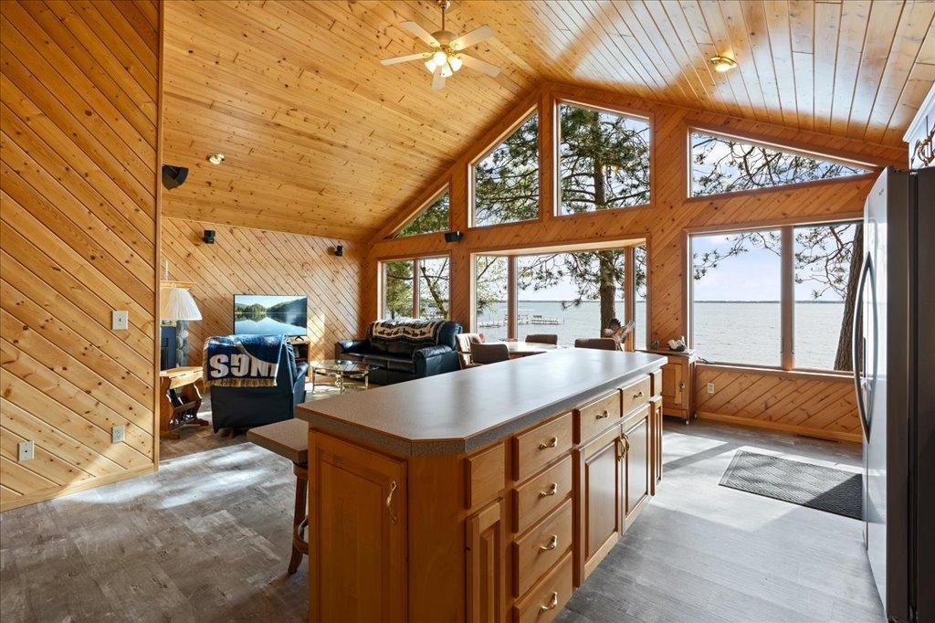 Open-concept living space with vaulted wood ceilings and panoramic lake views.