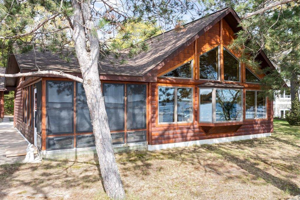 Lakeside cabin with expansive windows and warm wood log siding exterior.