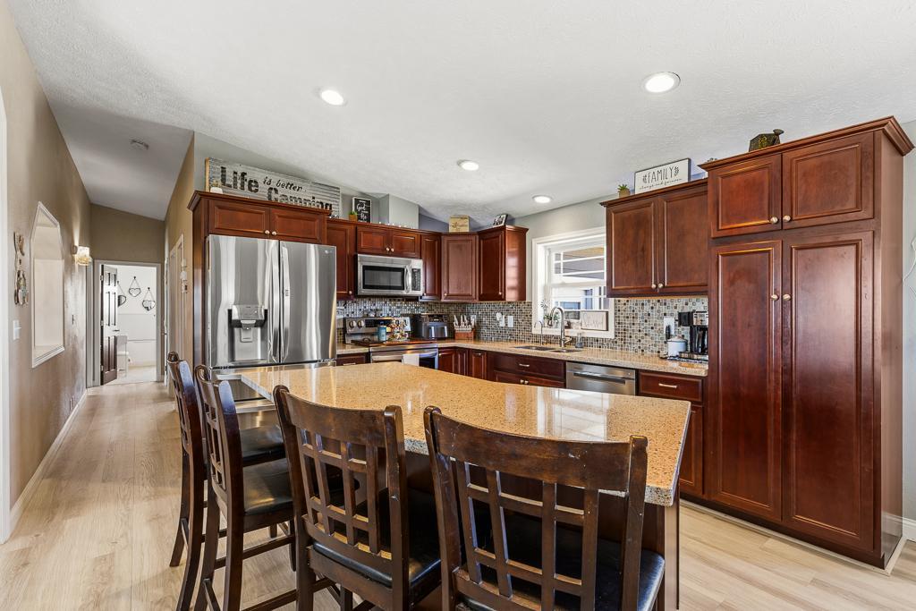 Highlights for this kitchen feature beautiful cabinetry, stainless steel appliances, tile backsplash, and quartz countertops