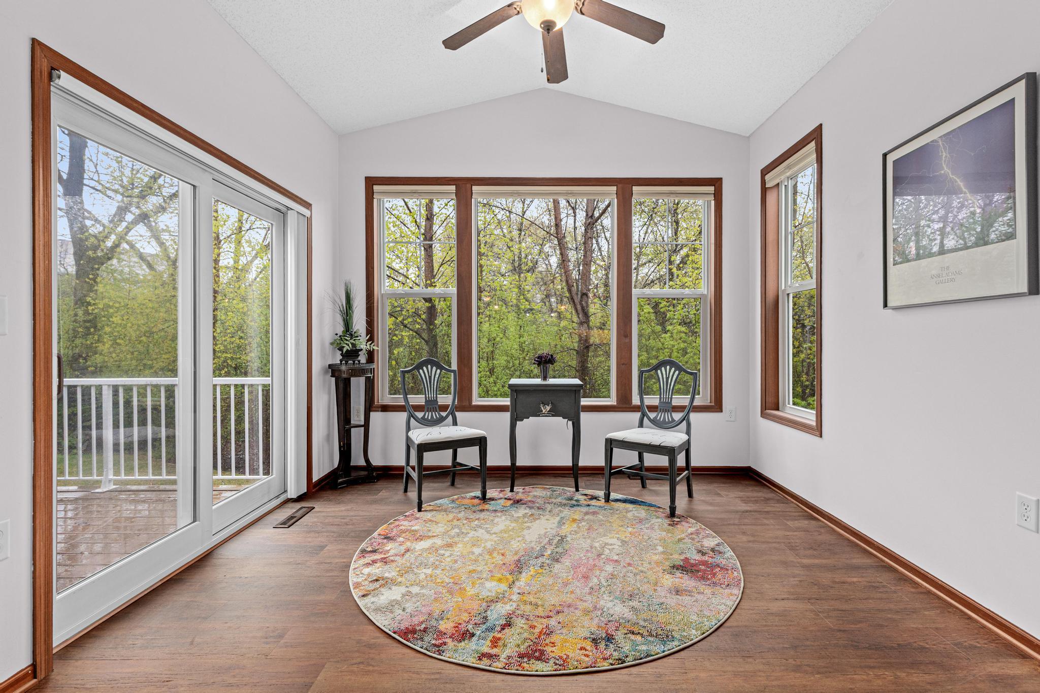 This light-filled sunroom offers flexible living space with direct access to the deck and peaceful wooded views.