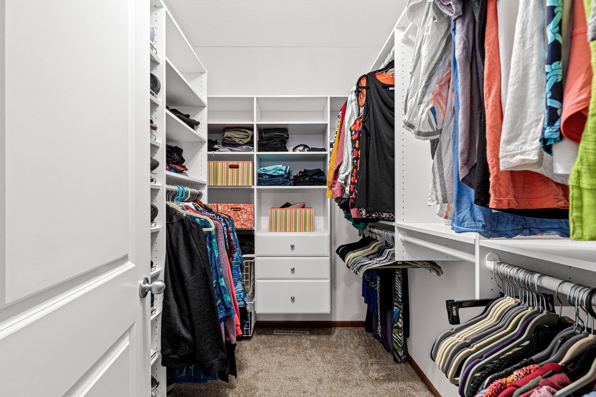 This walk-in closet includes storage systems to keep belongings accessible and organized.