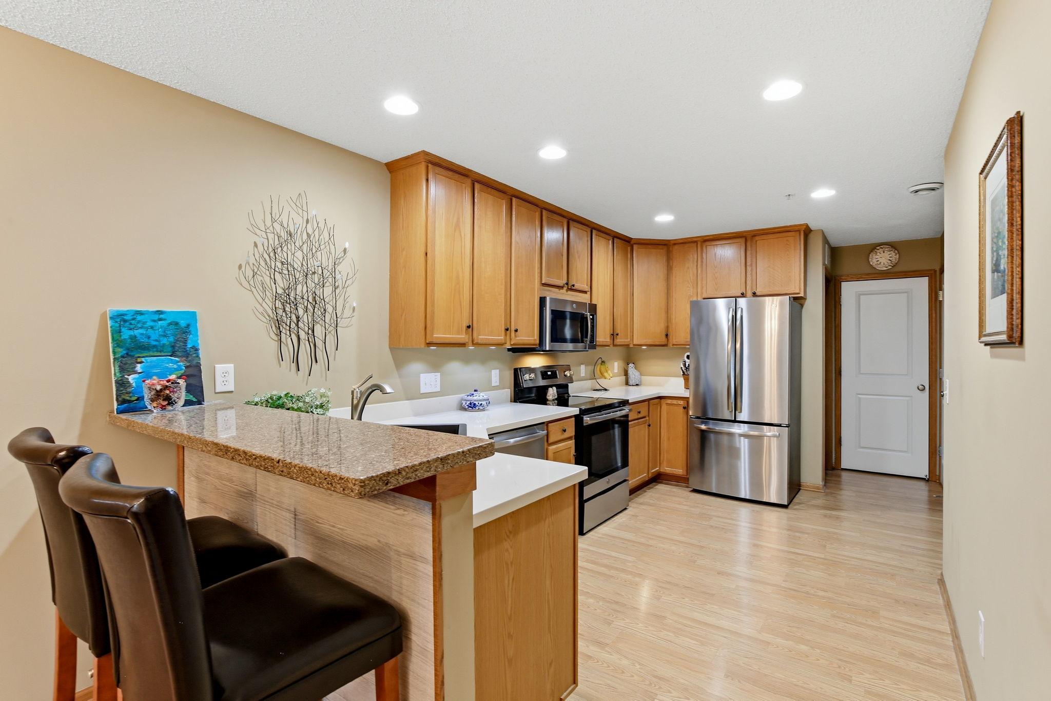 The eat-in kitchen area includes a convenient counter space that accommodates bar stools, perfect for casual dining or gathering.