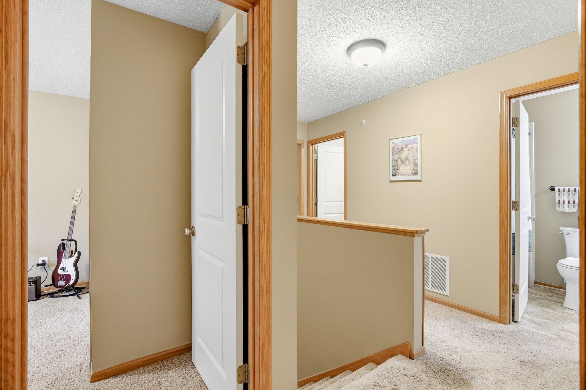 The upper-level landing provides access to three bedrooms and a conveniently located laundry room.