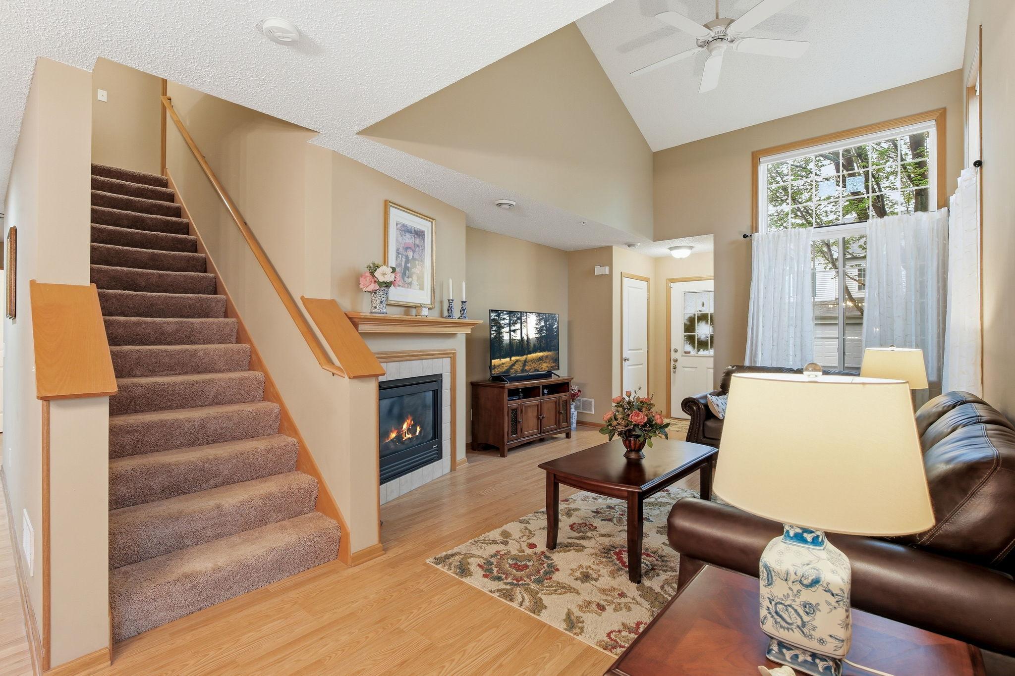 The main-level living room features a vaulted ceiling and provides access to the upstairs, creating an open, connected feel.