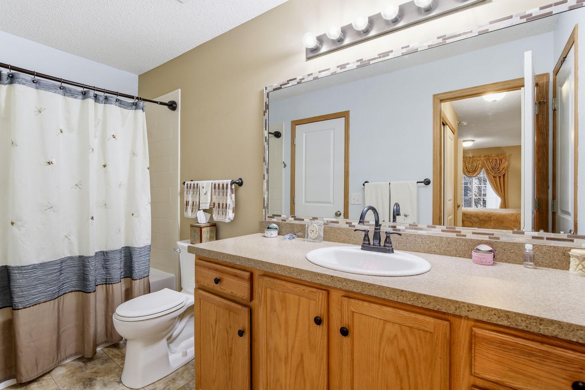 The upper-level full bathroom is light and bright, creating a clean, refreshing space.