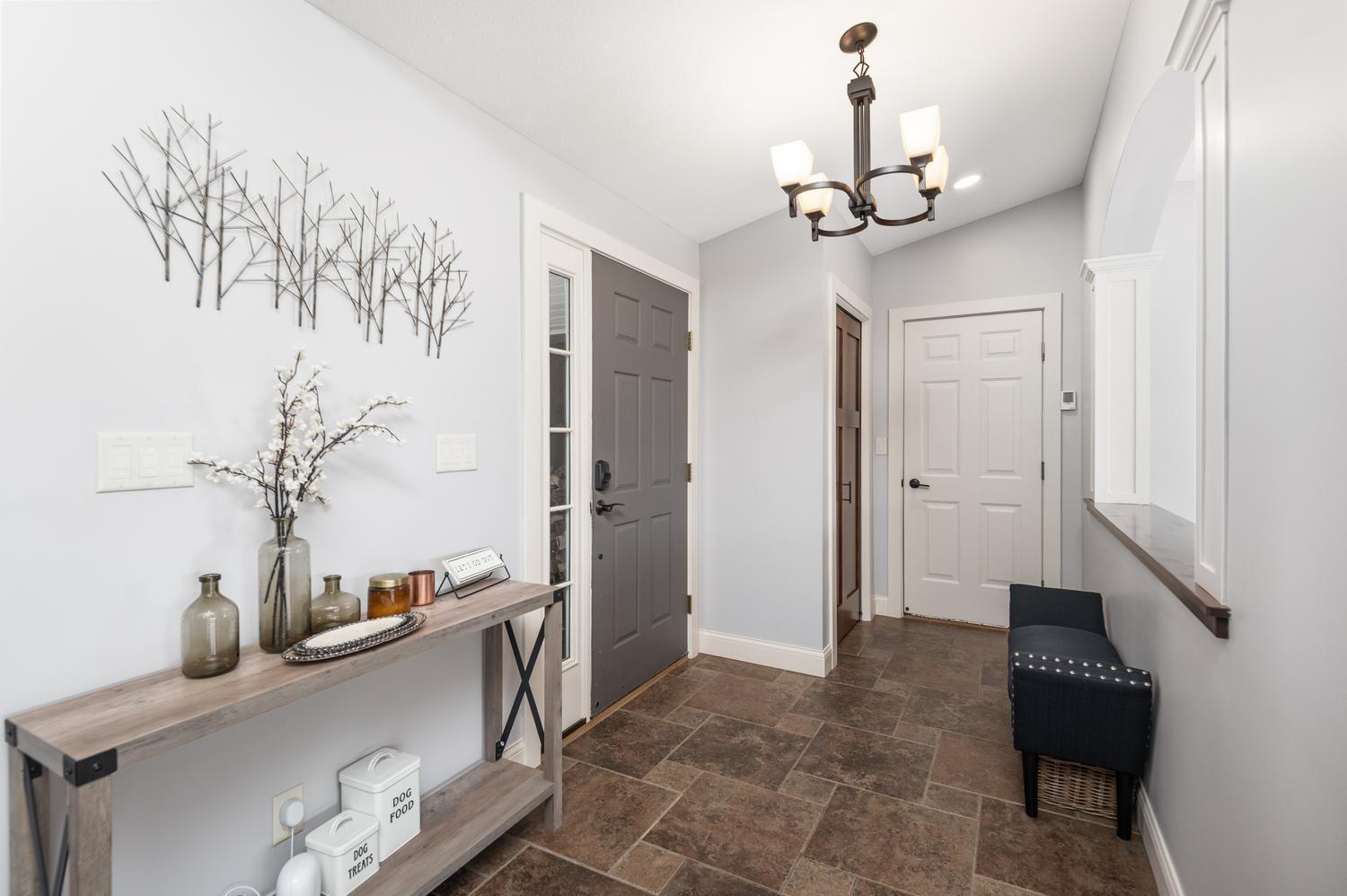 Come through the covered entryway to the spacious foyer area. You immediately catch the view the back yard and the lake.
