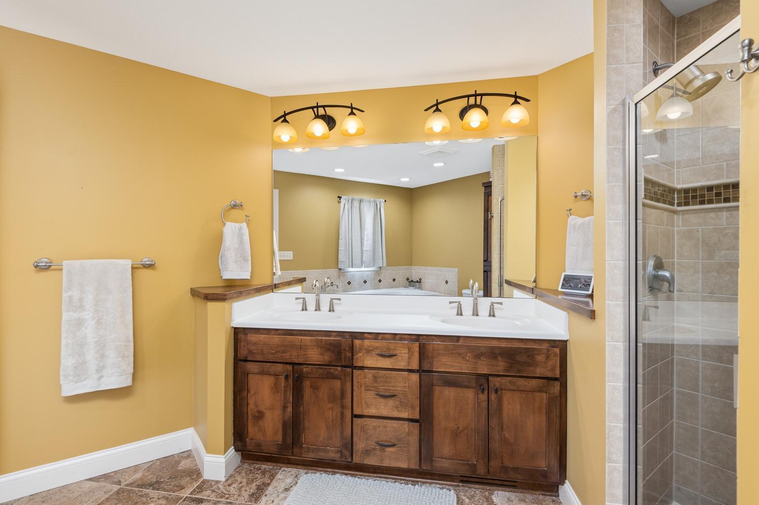 Very spacious primary bath with double vanity, tile flooring, tile shower and whirlpool tub.