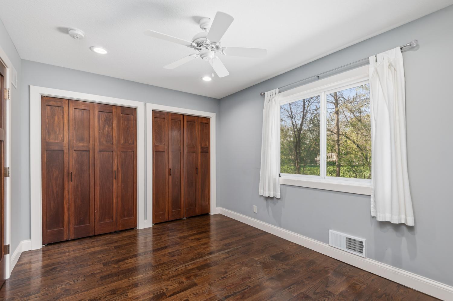 The second main floor bedroom with wood plank floor and double closet.