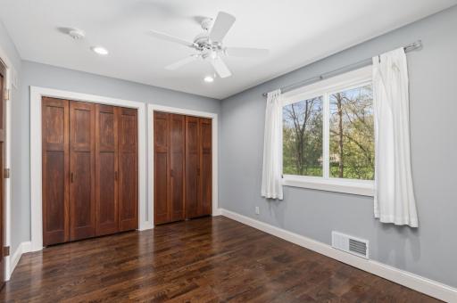 The second main floor bedroom with wood plank floor and double closet.