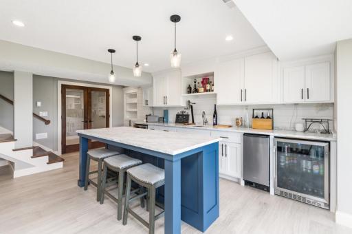 Entertain with all new cabinetry, premium white marble counter top, wine cooler, ice maker and refrigerator. Step out to the patio and lake.
