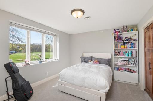 The fourth bedroom in the lower level overlooks the back yard and lakeshore. A door steps out to the patio. Outstanding guest room!