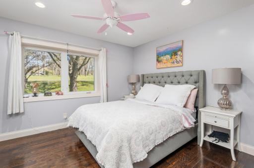 The third bedroom on the main floor. Beautiful wood plank floors, recessed lighting and pink ceiling fan.