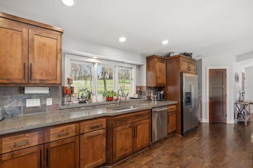 There is abundant cabinetry and drawer space, a pantry closet, recessed lighting, slate backsplash and useful counter space.