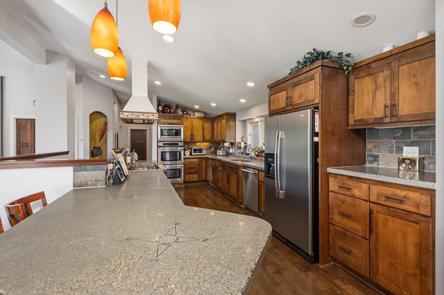 The kitchen remodel offers updated cabinetry, premium stainless appliances, cement countertops and wood plank floors.