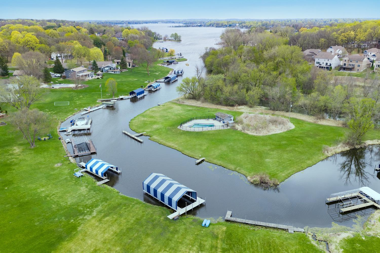 Spacious rambler rests on a 1.1 acre lot with 102 feet of protected shoreline plus a private island with a swimming pool!