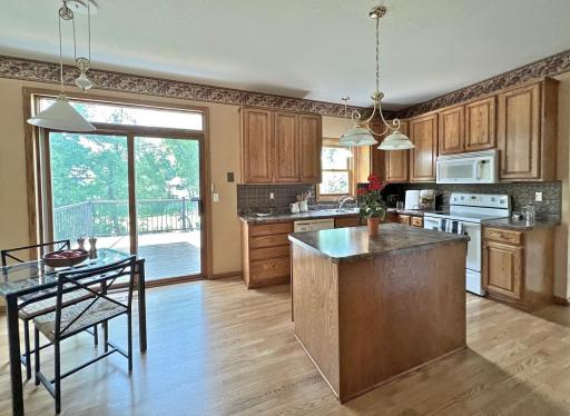 Well-appointed kitchen featuring a center island, abundant cabinetry, hardwood floors, and natural light