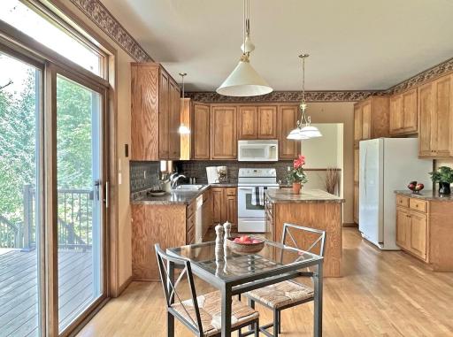 Informal dining area with hardwood floors, backyard views, and sliding-glass-door access to the deck w/views of pond