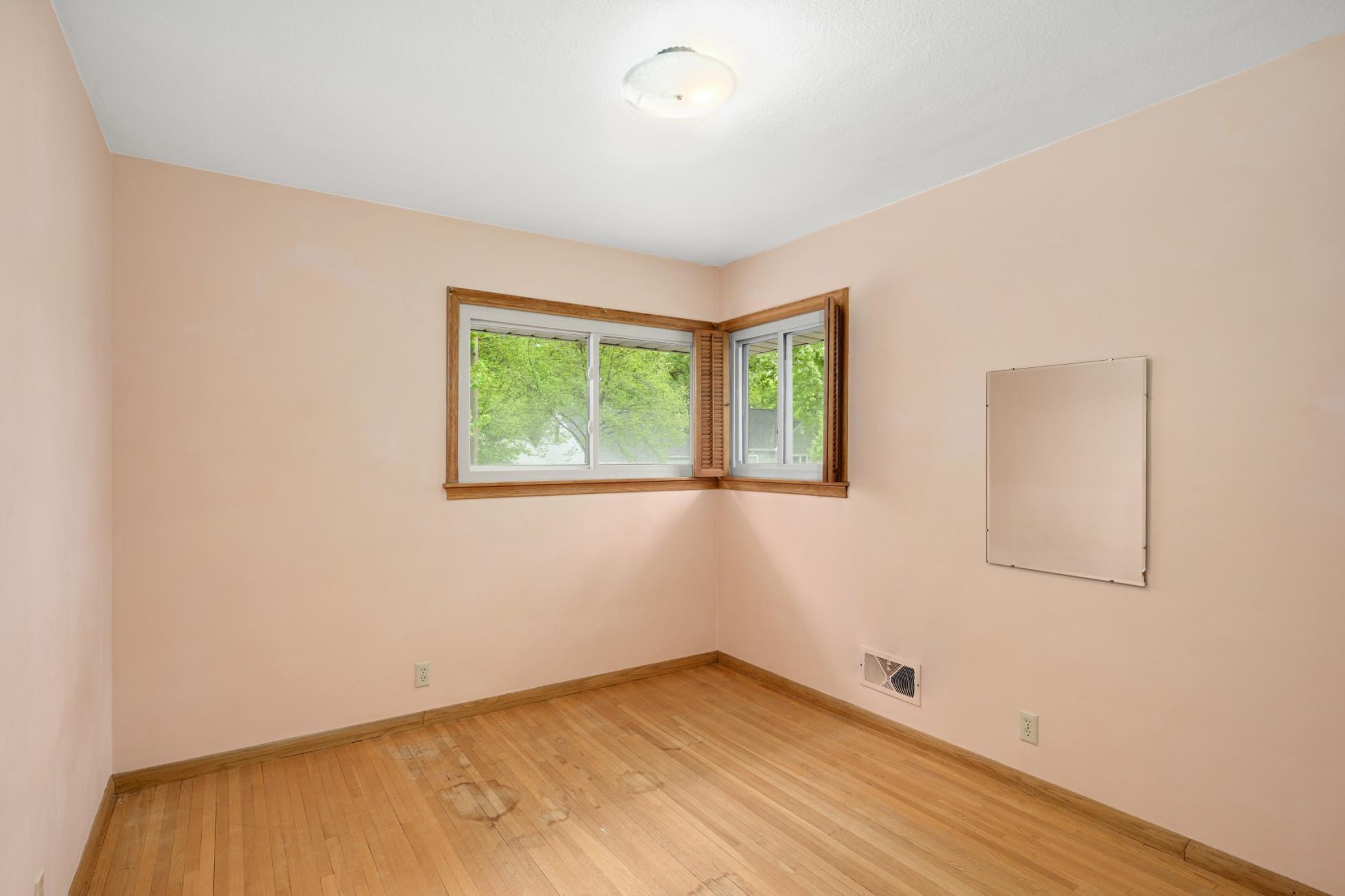 3rd bedroom (10' x 9') with corner windows and original hardwood floor.