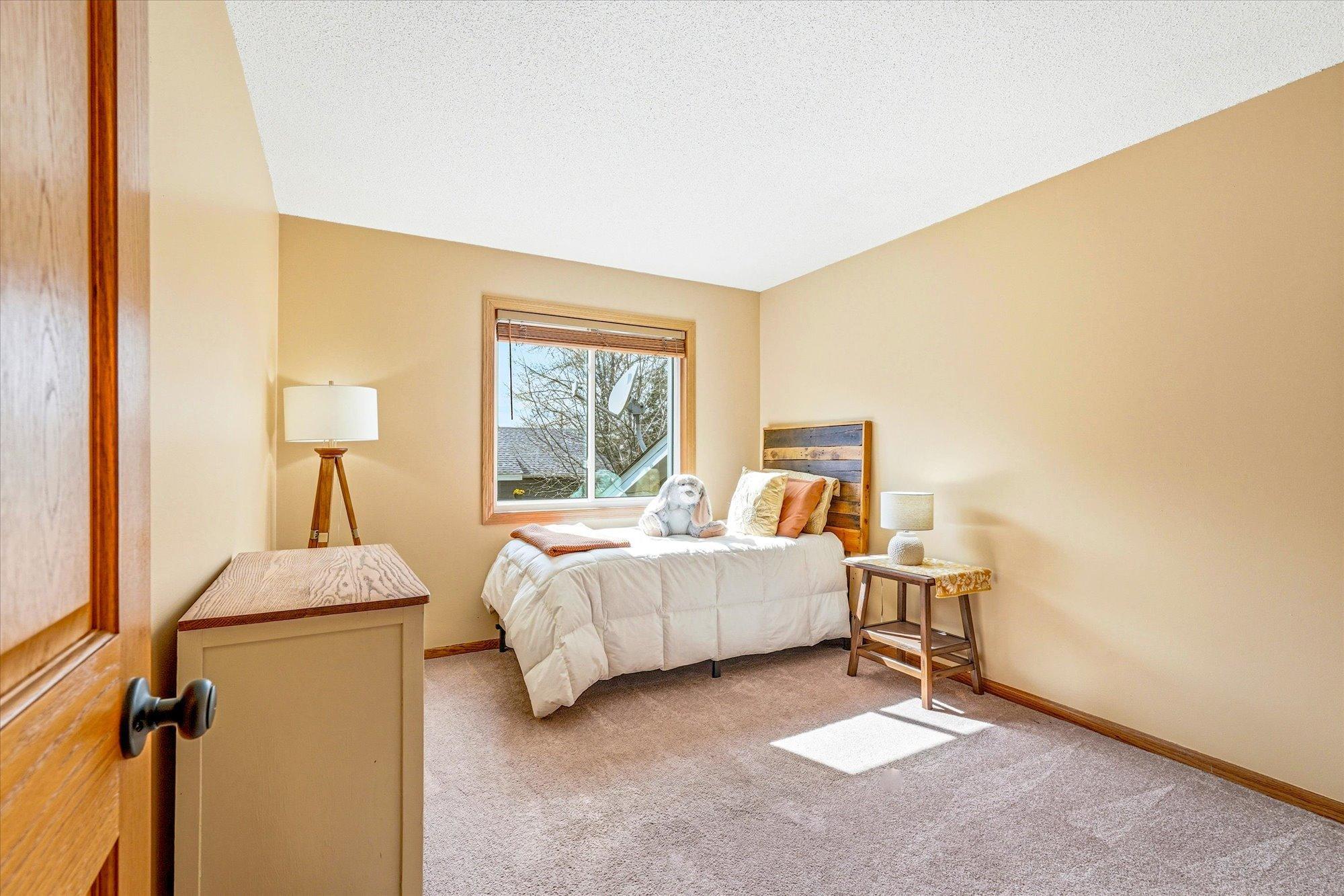 Bright secondary bedroom with neutral finishes, large closet, and abundant natural light.
