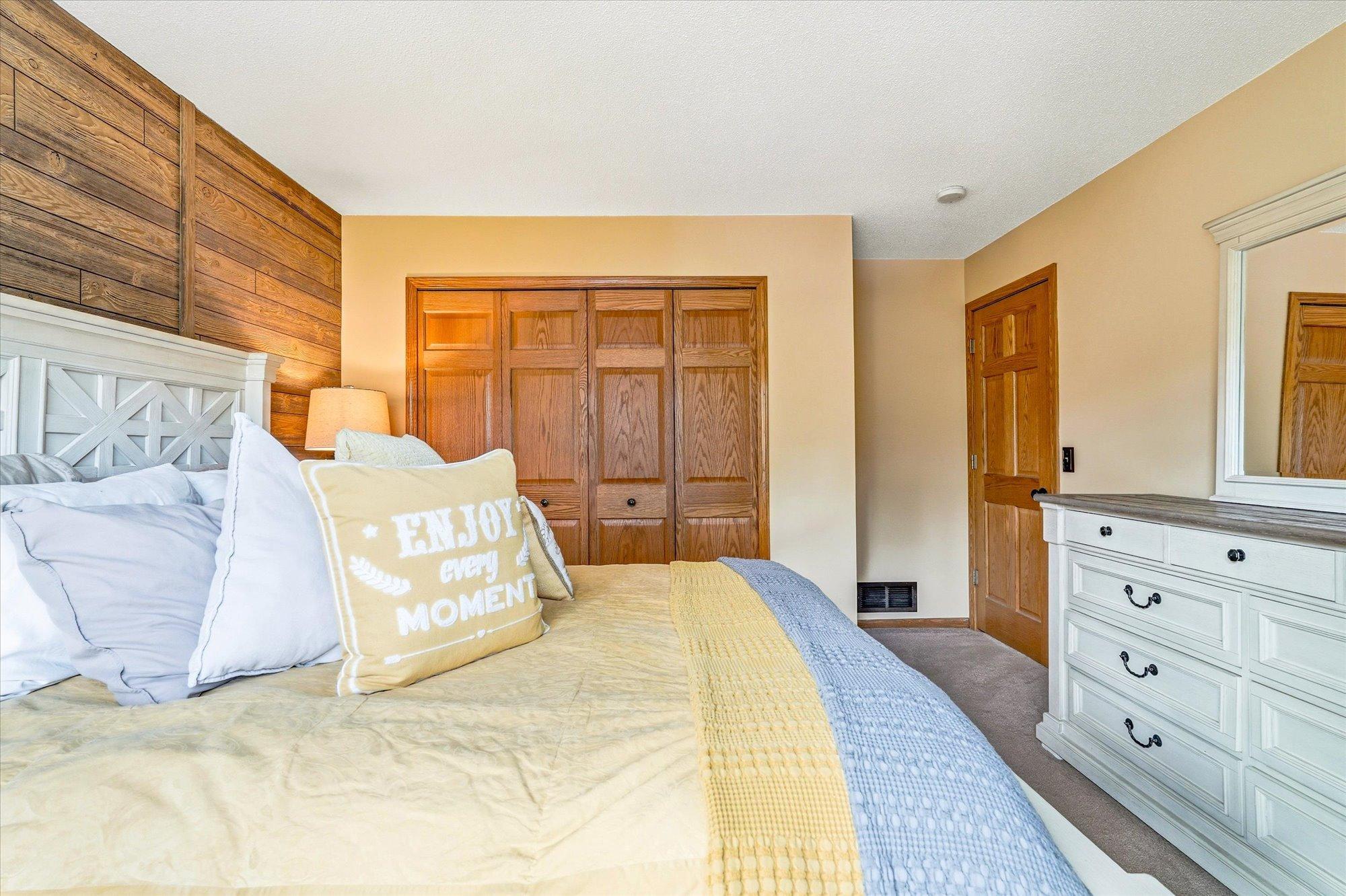 Another view of the spacious primary bedroom showcasing ample closet space and solid wood doors.