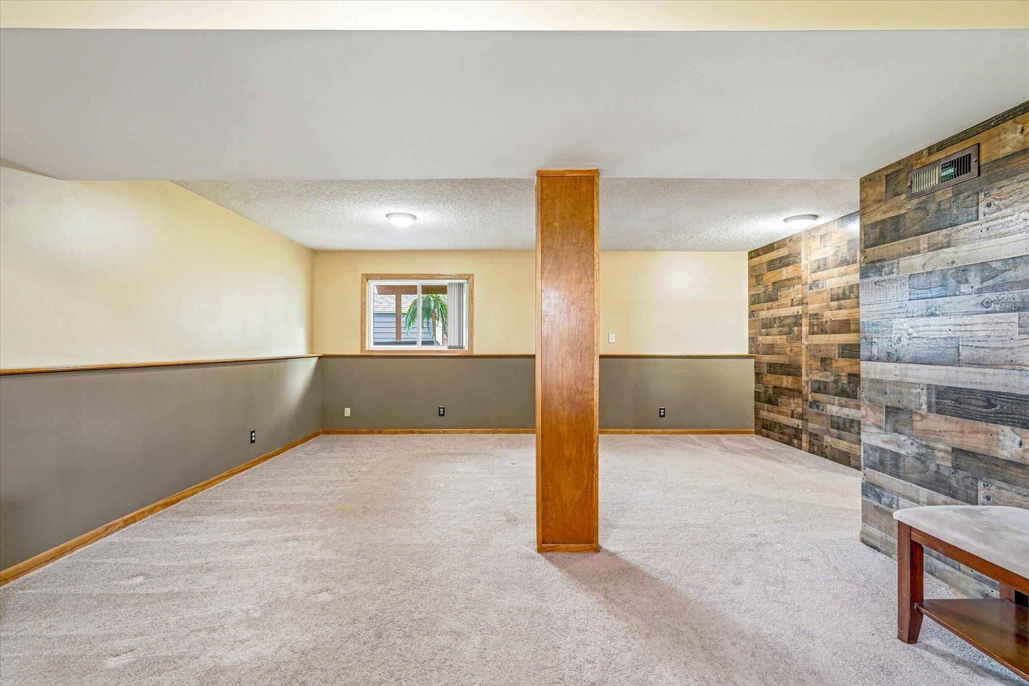 Another view of the spacious lower-level family room with updated finishes and versatile layout options.